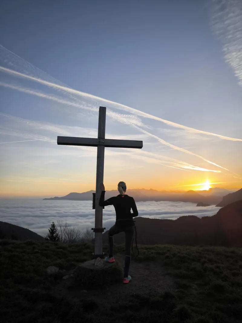Am Gipfelkreuz bei Sonnenaufgang über dem Nebelmeer
