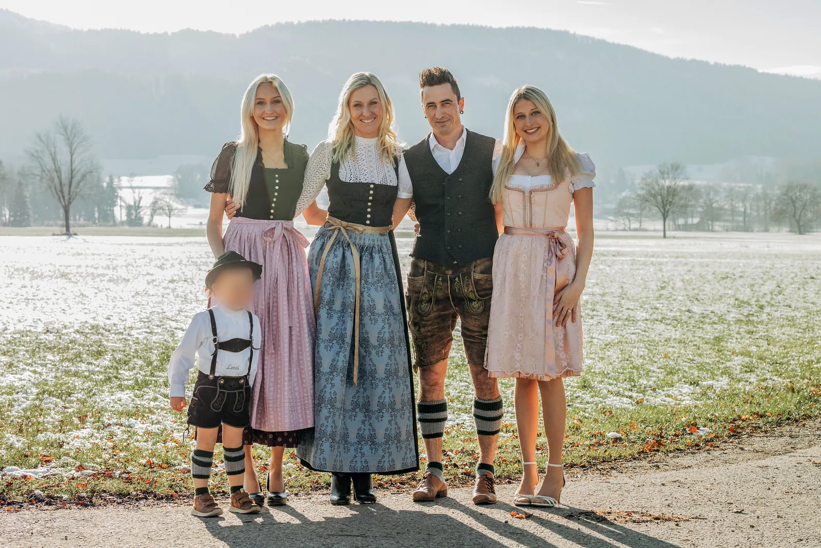 Familie Heiß in Tracht vor einer verschneiten Wiese