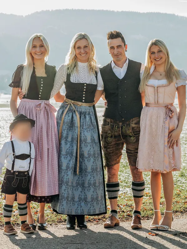 Familie Heiß in Tracht vor einer verschneiten Wiese